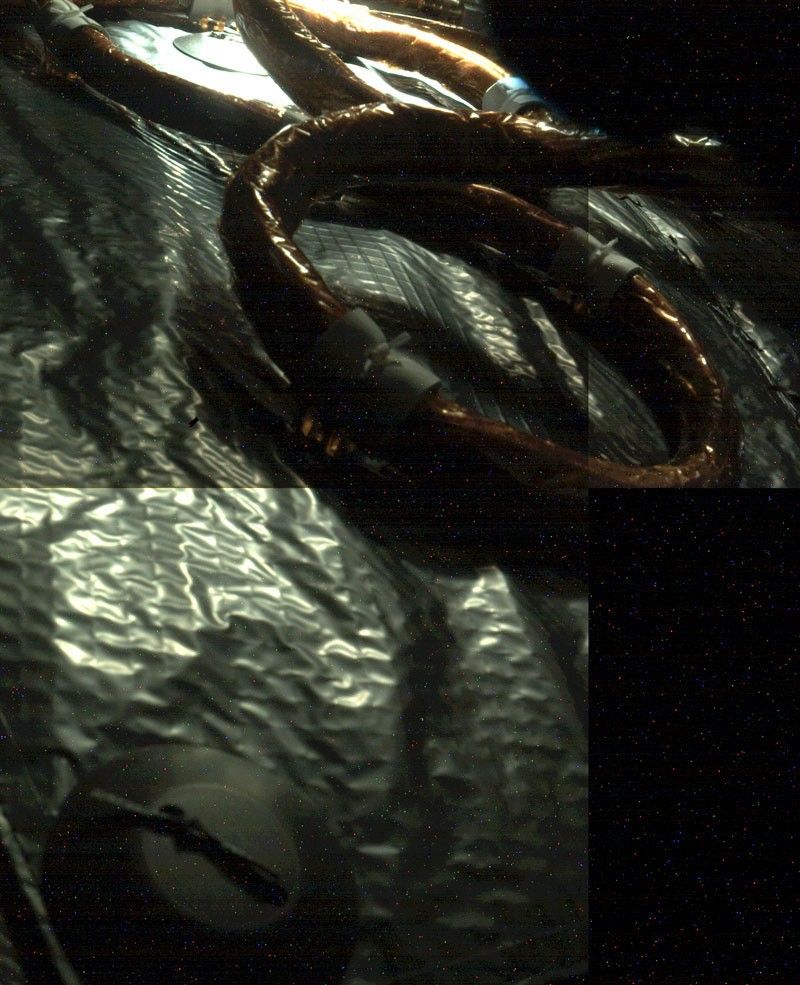 An electrical cable can be seen snaking its way along insulation material in this in-flight image of the interior of the Mars 2020 spacecraft