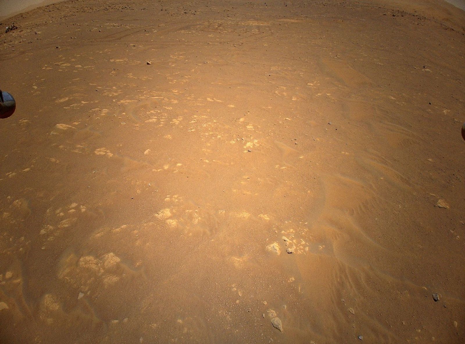 NASA’s Perseverance Mars rover is visible in the upper left corner of this image the agency’s Ingenuity Mars Helicopter took during its third flight, on April 25, 2021. The helicopter was flying at an altitude of 16 feet (5 meters) and roughly 279 feet (85 meters) from the rover at the time.