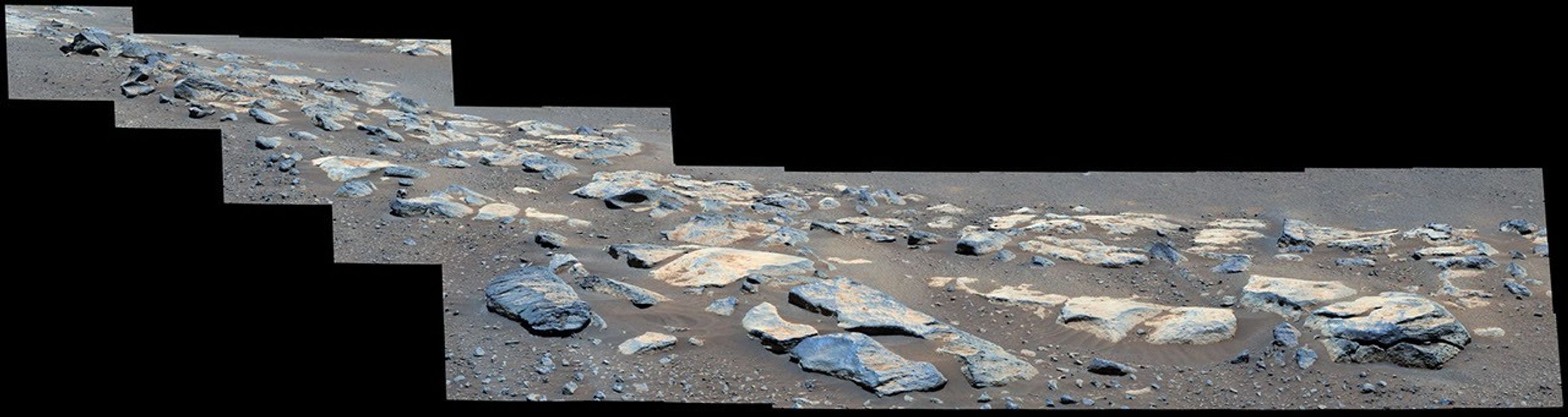 This is a colored image of large boulders on the sandy surface of Mars.