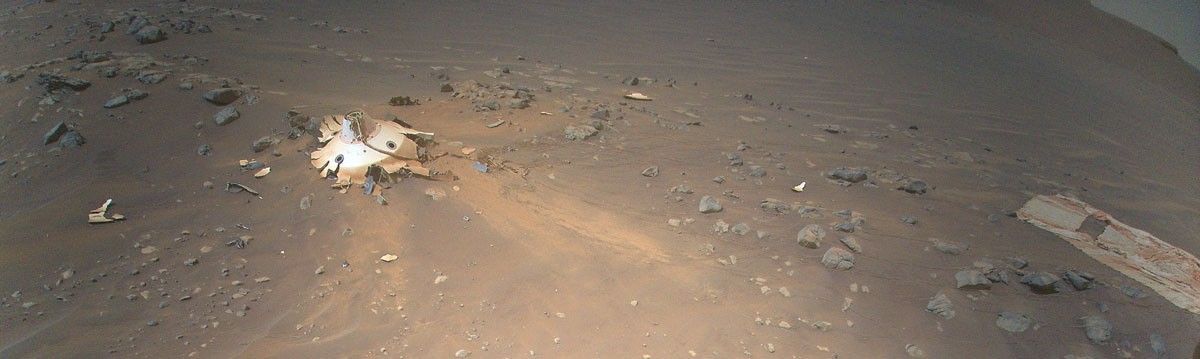 Perseverance’s backshell, supersonic parachute, and associated debris field is strewn across the Martian surface in this image captured by NASA’s Ingenuity Mars Helicopter during its 26th flight on April 19, 2022.