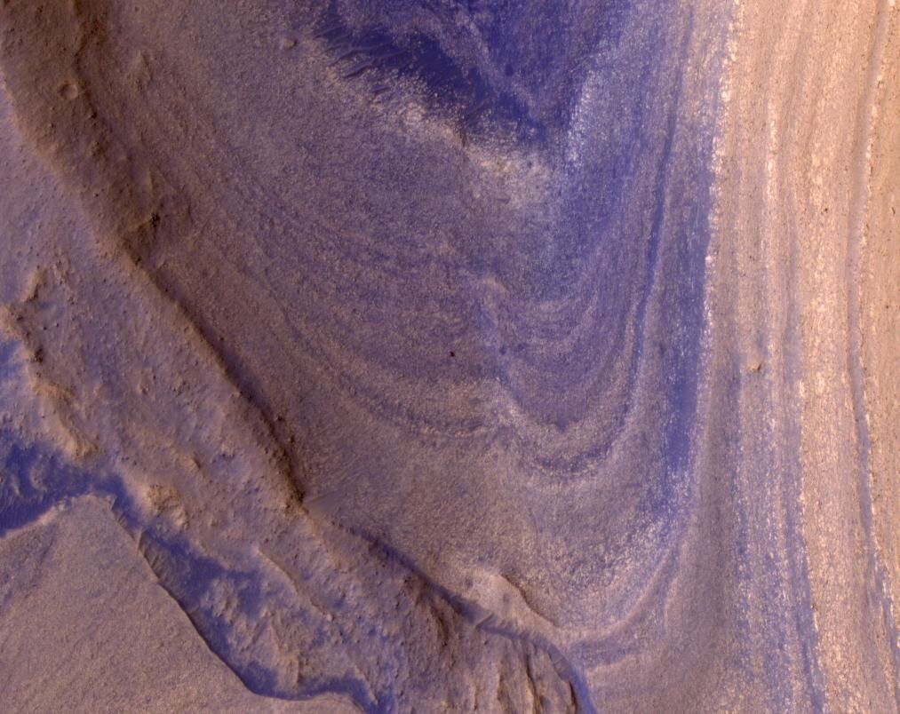 NASA's Curiosity Mars rover appears as a dark speck in this image captured from directly overhead by the agency's Mars Reconnaissance Orbiter, or MRO. The orbiter is equipped with a camera capable of viewing objects the size of a dinner table on the Red Planet's surface.
