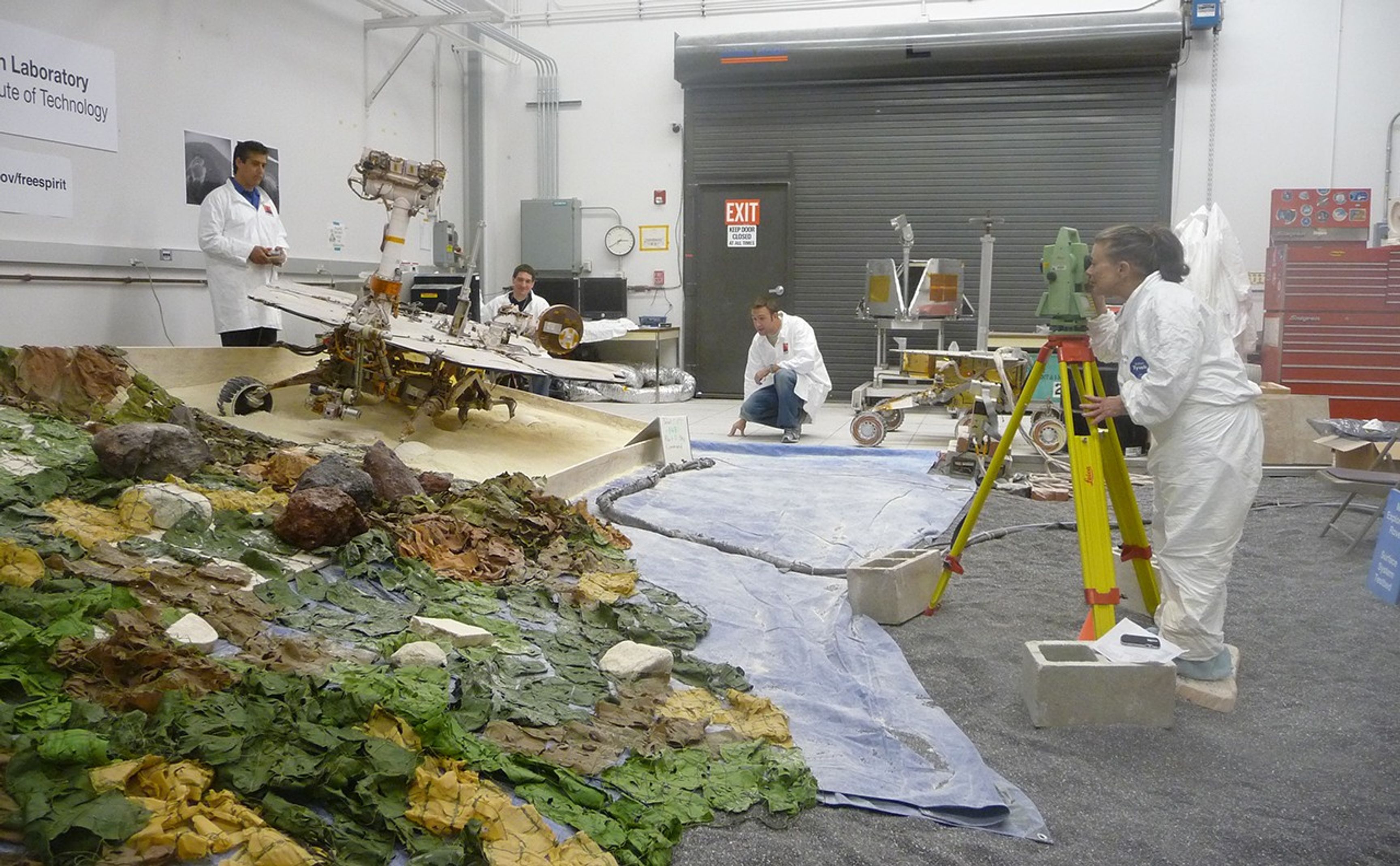 Rover-team members at NASA's Jet Propulsion Laboratory, Pasadena, Calif., check slight movements by a test rover during tests simulating the challenge of getting NASA's Mars Exploration Rover Spirit out of a sand trap on Mars. From left: Alfonso Herrera, Matt Van Kirk, Mike Seibert, Brenda Franklin.
