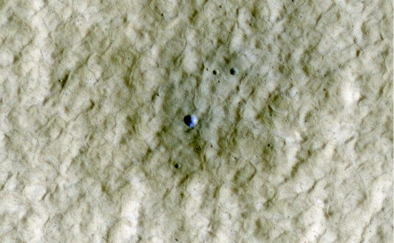 At the center of this view of an area of mid-latitude northern Mars, a fresh crater about 6 meters (20 feet) in diameter holds an exposure of bright material, blue in this false-color image.