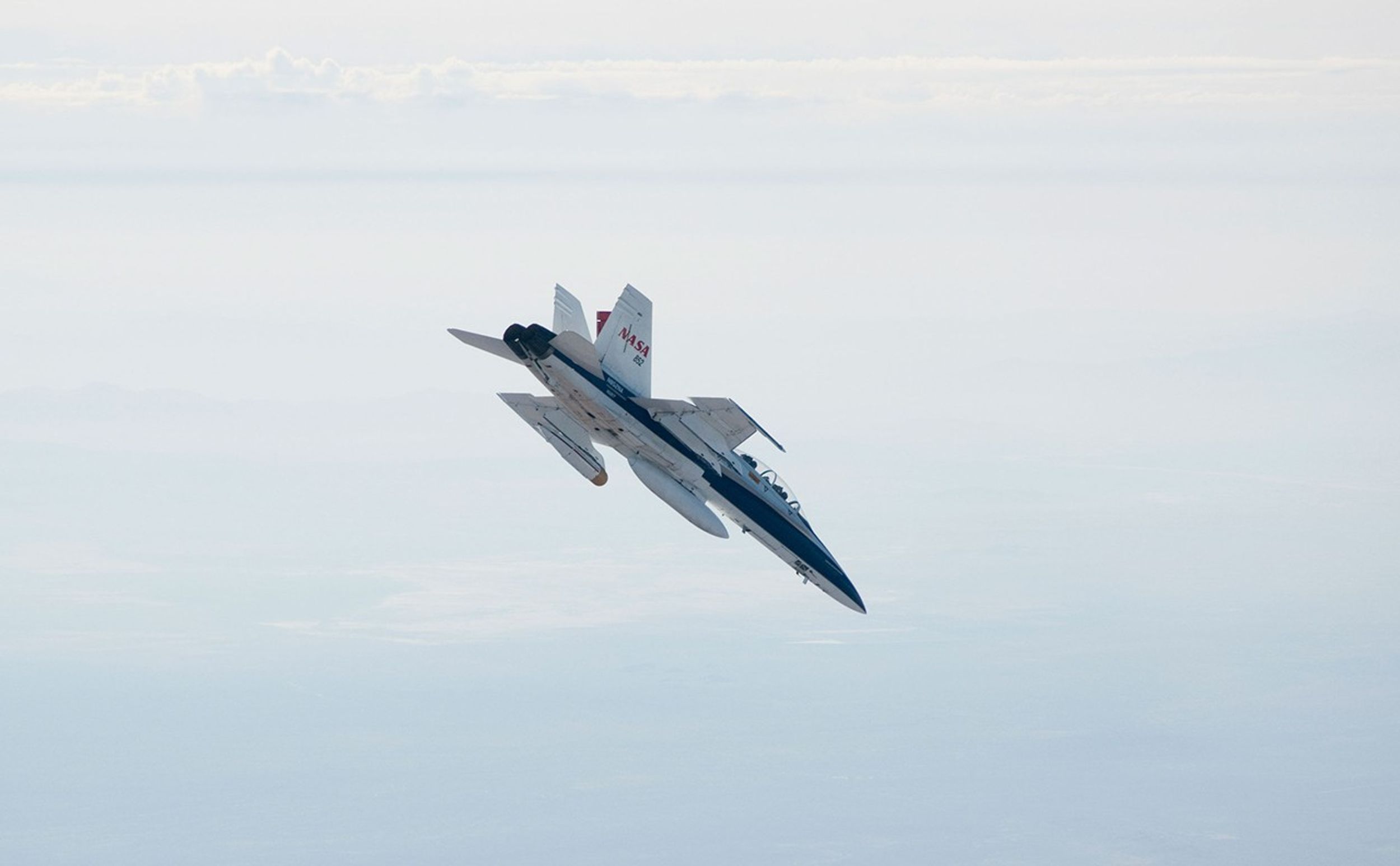 A NASA Dryden Flight Research Center F/A-18 852 aircraft makes a 40-degree dive toward Rogers Dry Lake at Edwards Air Force Base, Calif., during June 2011 flight tests of a Mars landing radar.