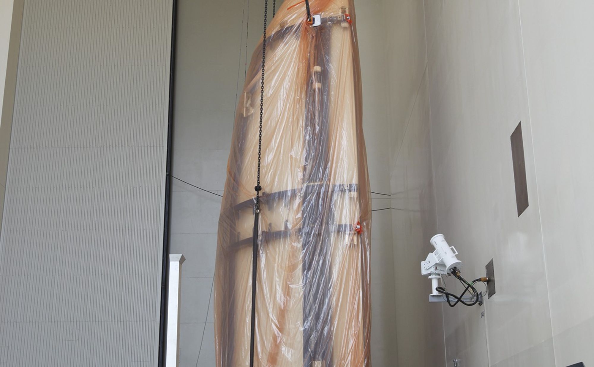 Half of the Atlas V payload fairing for NASA's Mars Science Laboratory (MSL) mission is lifted into a vertical position in the airlock of the Payload Hazardous Servicing Facility at NASA's Kennedy Space Center in Florida.