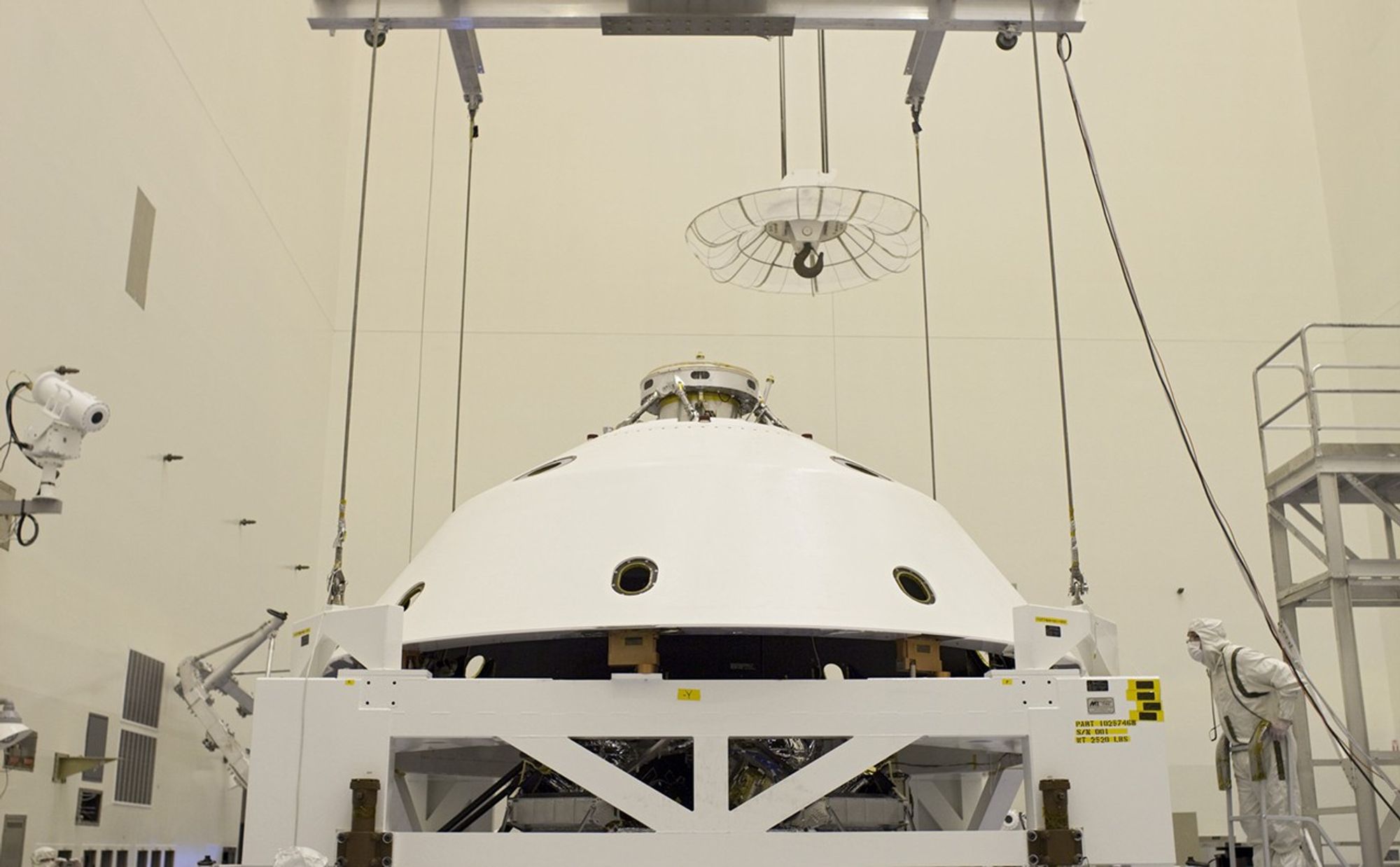 In the Payload Hazardous Servicing Facility at NASA's Kennedy Space Center in Florida, technicians guide the backshell as it is lowered over NASA's Mars Science Laboratory (MSL) rover, Curiosity, for encapsulation.