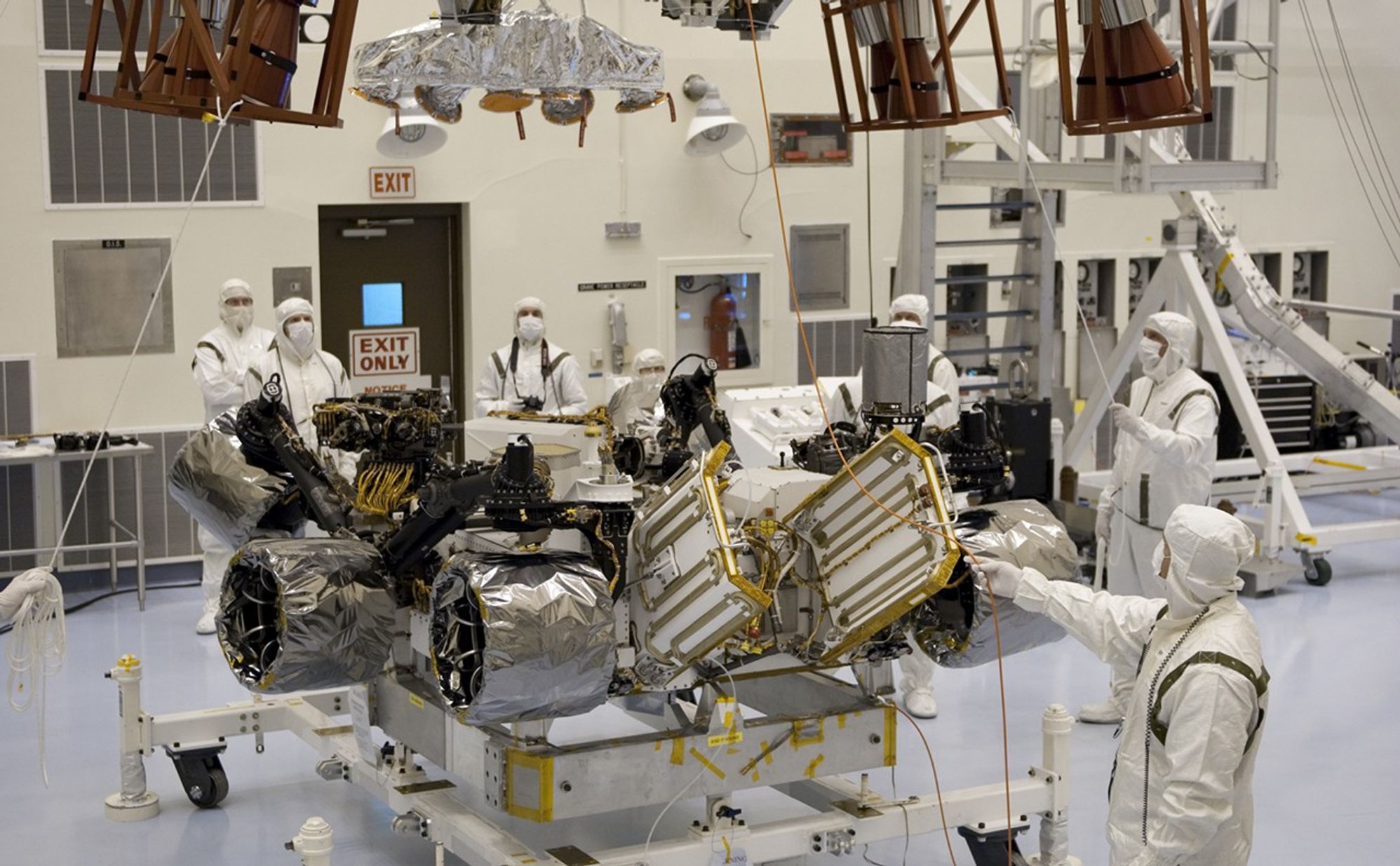 Under the watchful eyes of technicians at the Payload Hazardous Servicing Facility at NASA's Kennedy Space Center in Florida, an overhead crane lowers a rocket-powered descent stage over NASA's Mars Science Laboratory (MSL) rover, known as Curiosity, for integration.