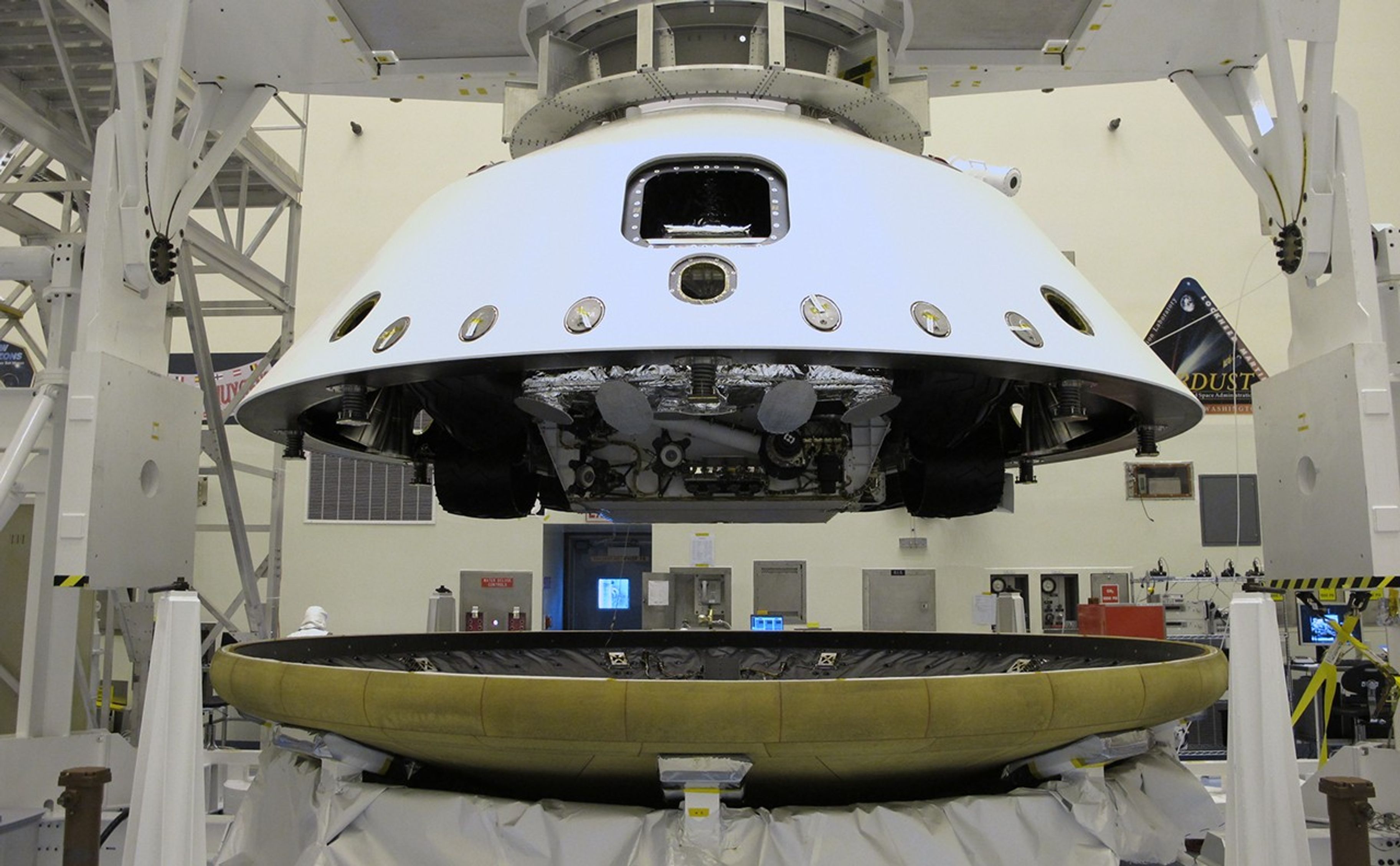 At the Payload Hazardous Servicing Facility at NASA's Kennedy Space Center in Florida, the "back shell powered descent vehicle" configuration, containing NASA's Mars Science Laboratory rover, Curiosity, is being placed on the spacecraft's heat shield.