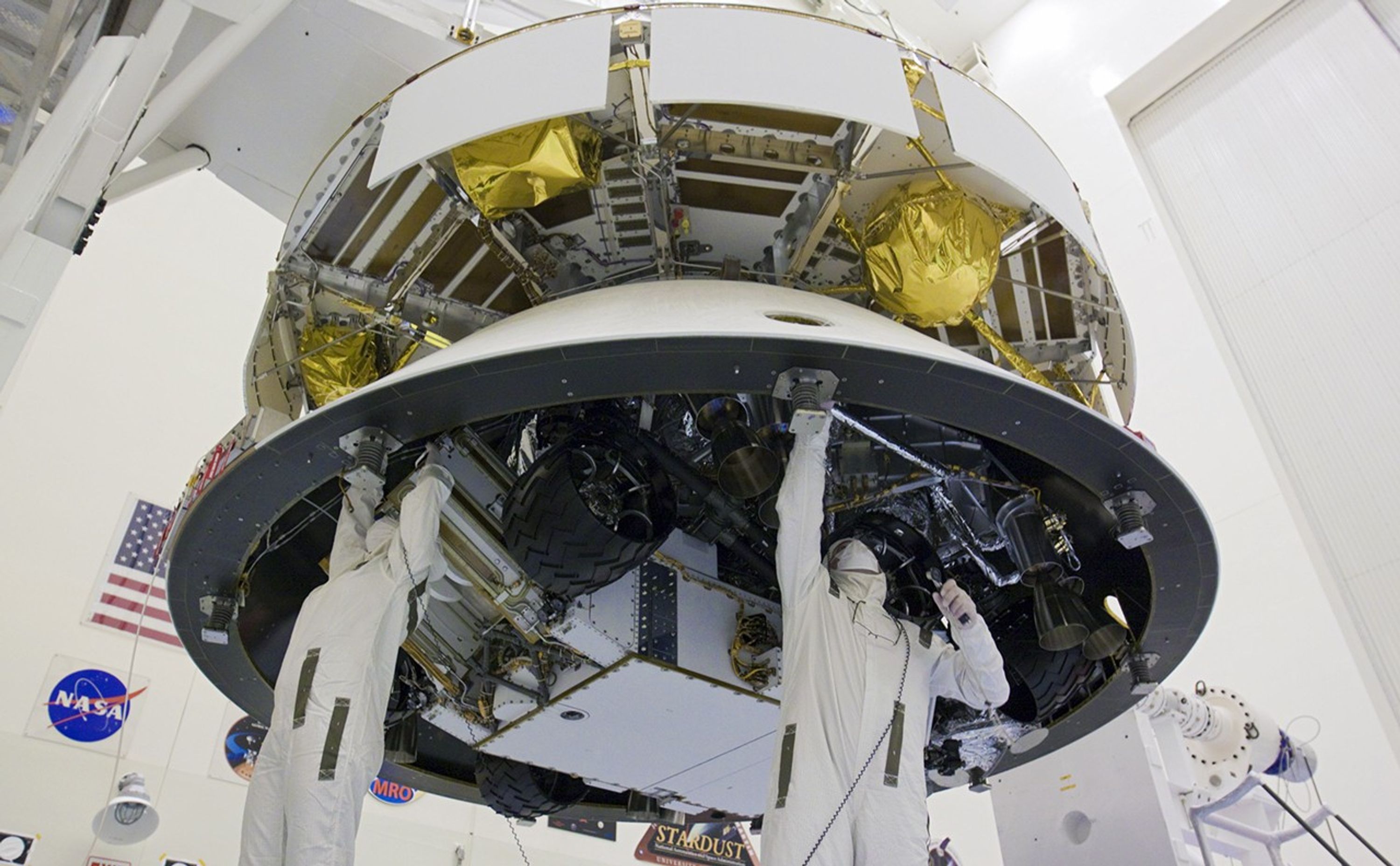 In the Payload Hazardous Servicing Facility at NASA's Kennedy Space Center in Florida, technicians work beneath NASA's Mars Science Laboratory (MSL) mission aeroshell, (containing the compact car-sized rover Curiosity), which has been mated to the cruise stage.