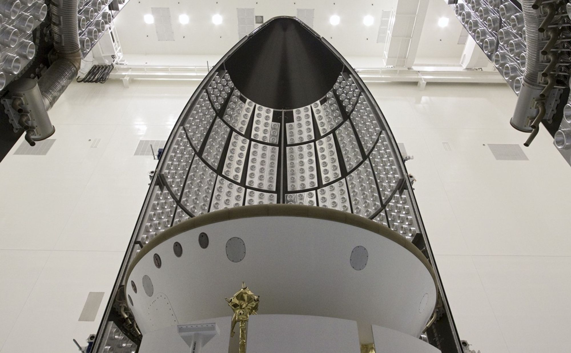 In the Payload Hazardous Servicing Facility at NASA's Kennedy Space Center in Florida, sections of an Atlas V rocket payload fairing engulf NASA's Mars Science Laboratory (MSL) as they close in around it.