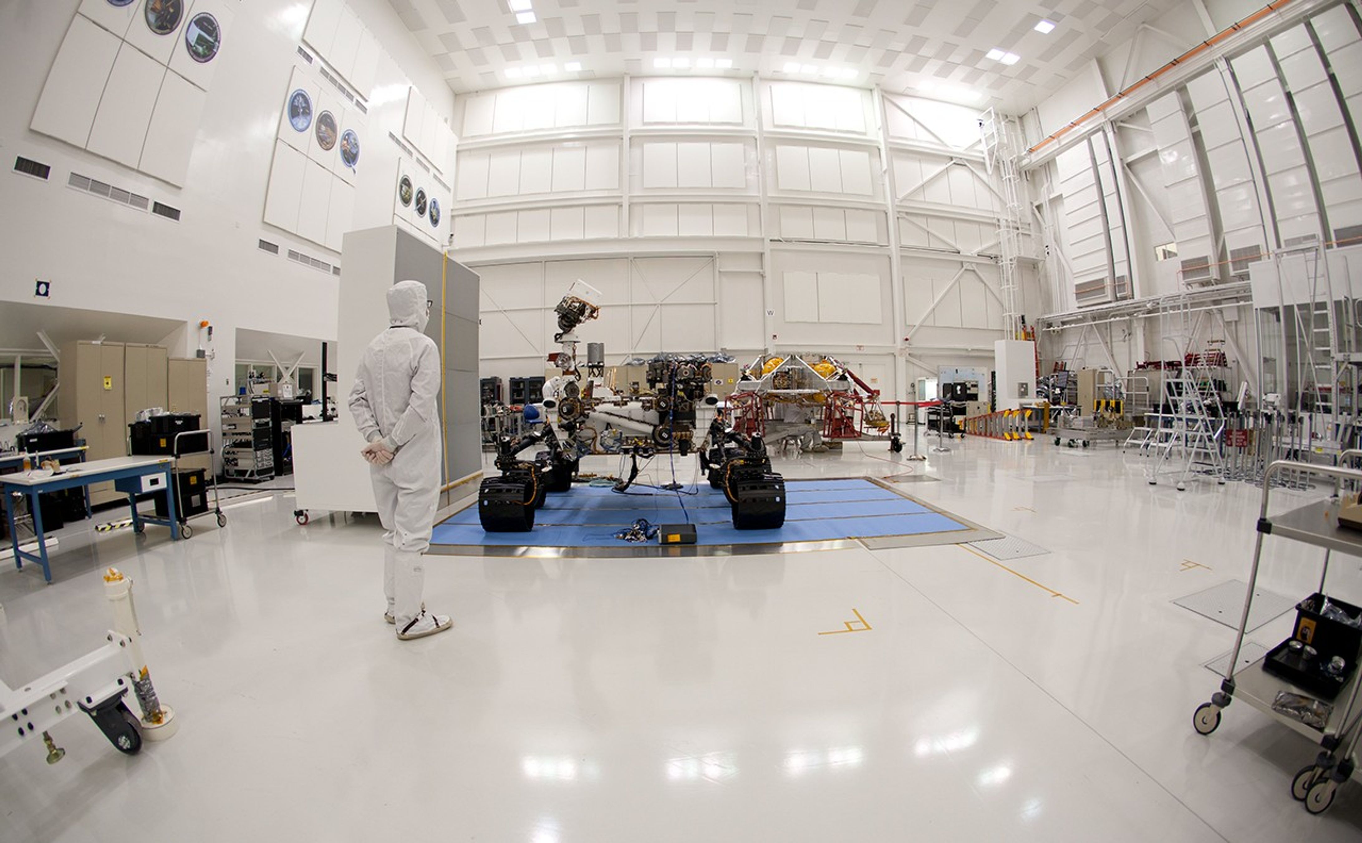 An engineer says goodbye to the Curiosity rover and its powered descent vehicle in the Jet Propulsion Laboratory's Spacecraft Assembly Facility shortly before the spacecraft was readied for shipment to Kennedy Space Center for launch.