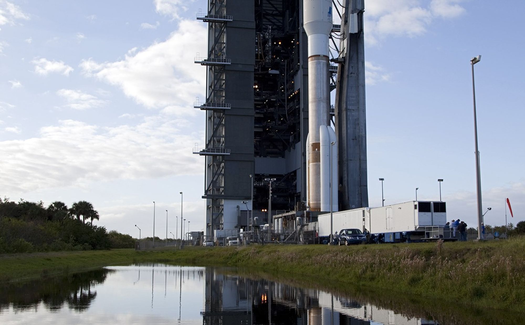 On Cape Canaveral Air Force Station in Florida, the 197-foot-tall United Launch Alliance Atlas V rocket moves away from the Vertical Integration Facility (VIF) during the vehicle's rollout to the launch pad at Space Launch Complex 41.