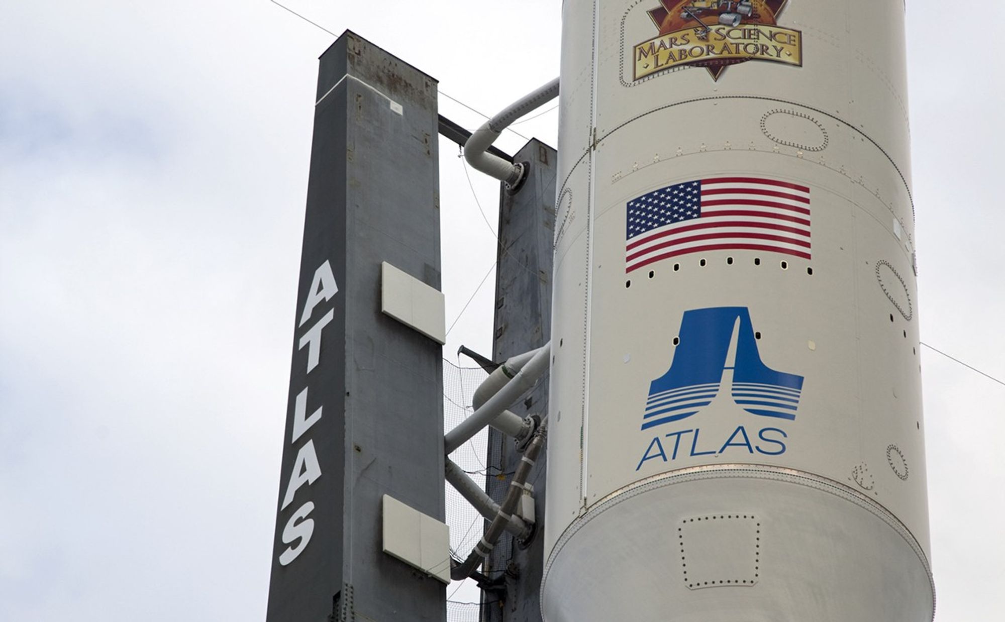 The NASA and Mars Science Laboratory (MSL) logos appear above the American flag and Atlas logo on the payload fairing atop the 197-foot-tall United Launch Alliance Atlas V rocket.