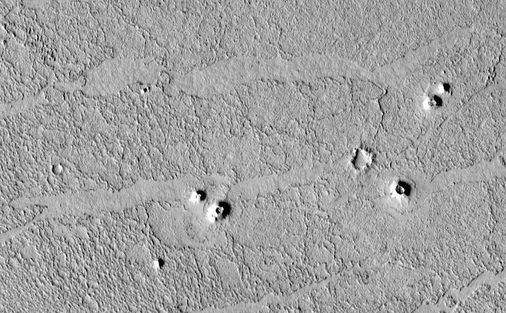 High-resolution images from the Mars Global Surveyor (MGS) Mars Orbiter Camera (MOC) have revealed small cone-shaped structures on lava flows in southern Elysium Planitia, Marte Valles, and northwestern Amazonis Planitia in the northern hemisphere of the red planet. The most likely interpretation of these cones is that they may be volcanic features known as "pseudo craters" or "rootless cones." They share several key characteristics with pseudo craters on Earth: they are distributed in small clusters independent of structural patterns, are superimposed on fresh lava flows, and they do not appear to have erupted lavas themselves