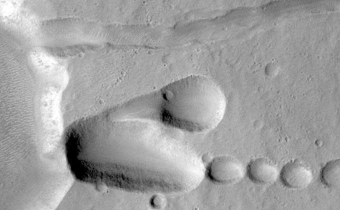As fractures opened near the summit of Tyrrhena Patera, the ground collapsed to make pits and chains of pits aligned with the fractures. The large pit seen here is about 400 m (1,300 ft) deep.