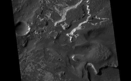 This HiRISE image covers the southwest portion of the terraces and floor of Holden Crater situated in southwest Margaritifer Terra. The HiRISE sub-frame shows the most clearly-evident image of a megabreccia on Mars. Breccia is a rock typically consisting of rock fragments of various sizes and shapes that have been broken, tumbled and cemented together in sudden geologic event (e.g., a landslide, a flashflood or even an impact-cratering event). If it were not for the dark sandy dunes dispersed through out the sub-image, this image could easily fool an expert into thinking that this image is actually a photograph of a hand sample of an impact breccia. The prefix "mega" implies that the breccia in the sub-image consists of clasts, or rock fragments, that are typically larger than a large house or a building. The rectangular megaclast near the center of the image is a colossal 50 x 25 meters (~150 X 75 feet). As mentioned in the transition image caption for Holden crater (TRA_000861_1530), the crater likely experienced extensive modification by running water, which is supported by observations of drainage and deposition into the crater from a large channel (Uzboi Valles) breaching Holden's southwest rim. While it is possible that the megabreccia formed from a catastrophic release of water into the crater, a more likely possibility is that it formed from the impact that created the approx. 150 km-in-diameter Holden crater. Popigai Crater, a terrestrial crater of half the size of Holden, possesses a similar occurrence of megabreccia with a similar range in megaclast size to the Holden crater example. An impact-generated megabreccia deposit, as observed in terrestrial craters, typically lies beneath the crater floor, so the exhumation of the megabreccia may be the result of down-cutting and erosion of water that once flowed through Uzboi Valles.