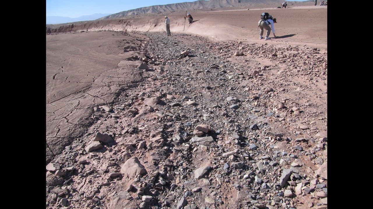 This image shows a dry streambed on an alluvial fan in the Atacama Desert, Chile, revealing the typical patchy, heterogeneous mixture of grain sizes deposited together.