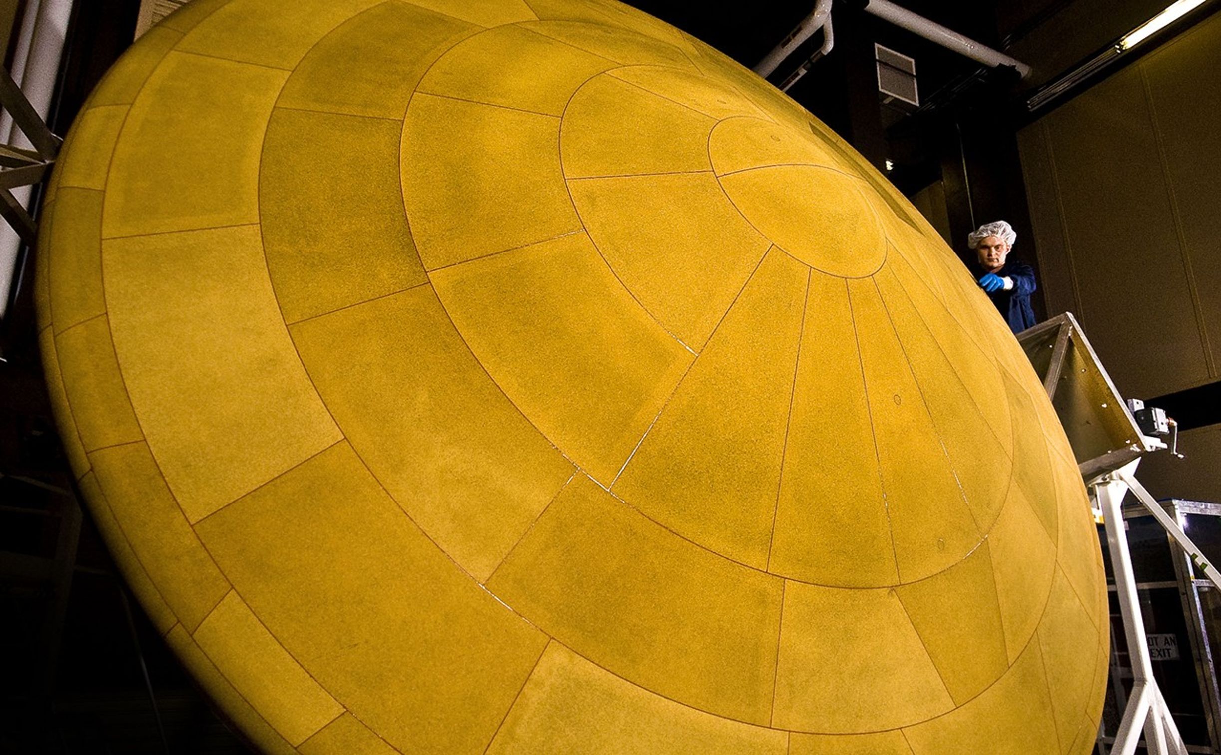 The finished heat shield for NASA's Mars Science Laboratory, with a diameter of 4.5 meters (14 feet, 9 inches), is the largest ever built for descending through the atmosphere of any planet. This image shows the heat shield and a spacecraft worker at Lockheed Martin Space Systems, Denver, which built and tested the heat shield.