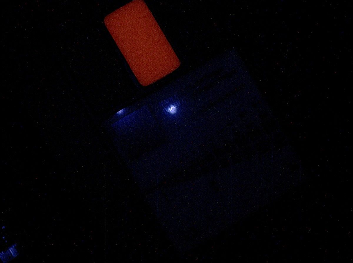 This image of a calibration target illuminated by ultraviolet LEDs (light emitting diodes) is part of the first set of nighttime images taken by the Mars Hand Lens Imager (MAHLI) camera at the end of the robotic arm of NASA's Mars rover Curiosity.