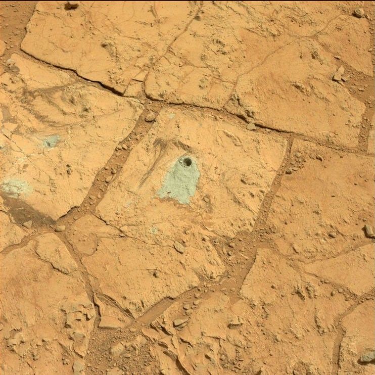 A blink pair of images taken before and after Curiosity performed a "mini drill" test on a Martian rock shows changes resulting from that activity.