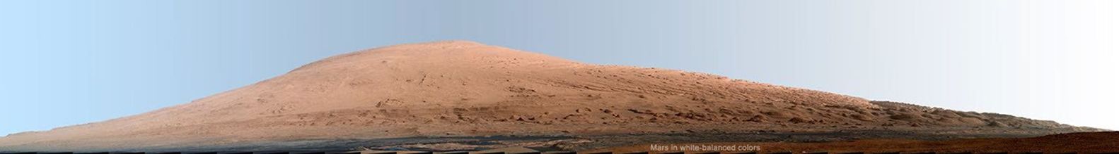 This mosaic of images from the Mast Camera (Mastcam) on NASA's Mars rover Curiosity shows Mount Sharp in a white-balanced color adjustment that makes the sky look overly blue but shows the terrain as if under Earth-like lighting.