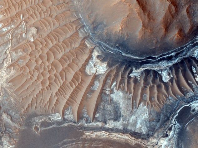 This image reveals exposed layers in Noctis Labyrinthus which may contain signatures of iron bearing sulfates and phyllosilcate (clay) minerals.