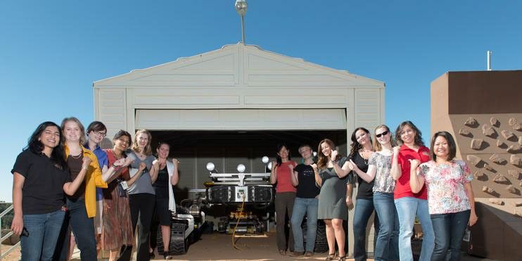 This is a picture of some of the women working on the Curiosity rover posing with Curiosity's mobility double, "Scarecrow," used to test drive under different soil conditions in the JPL "Mars Yard."