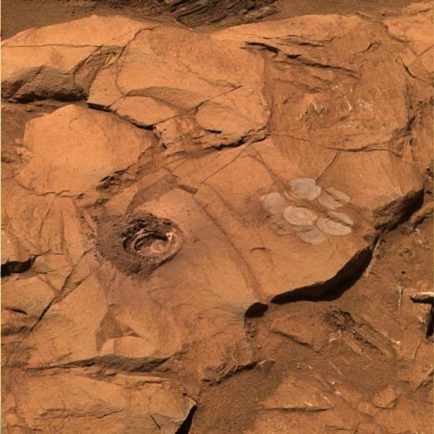 At a rock called "Clovis," the rock abrasion tool on Spirit cut a 9-millimeter (0.35-inch) hole.  To the right of the drill hole  is a "brush flower" of circles produced by scrubbing the surface of the rock with the abrasion tool's wire brush.