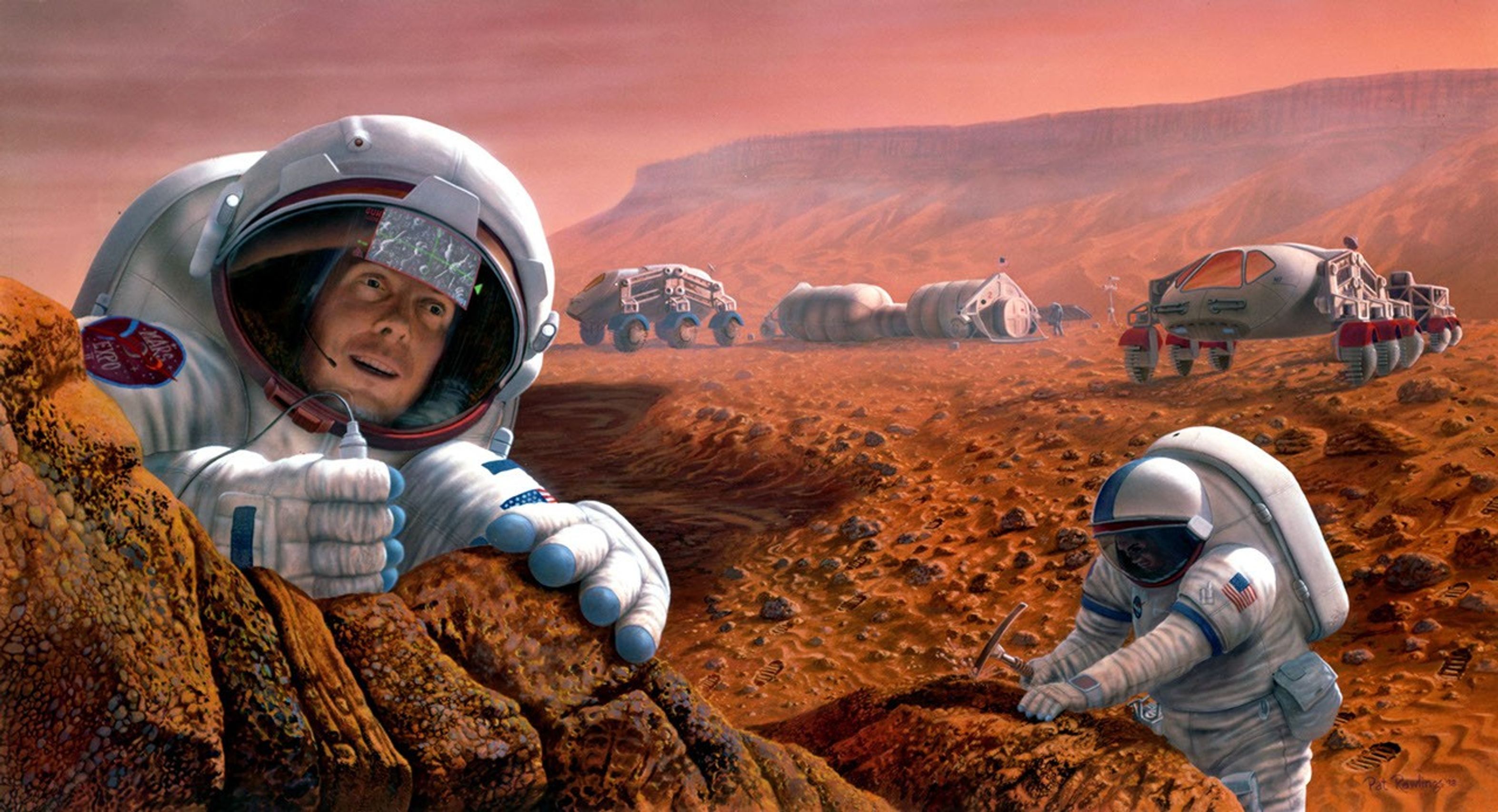 Two astronauts study a rock formation on Mars. One is seen chipping away at a rock. Two vehicles and an outpost are seen in the background.