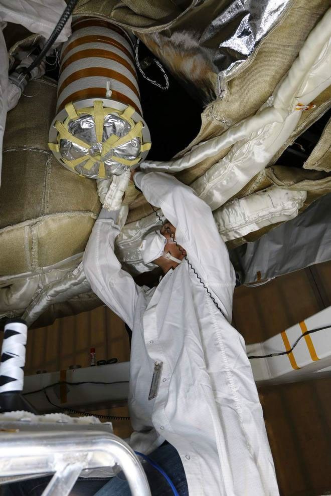 An engineer works on the Parachute Deployment Device of the Low Density Supersonic Decelerator test vehicle in this image taken at the Missile Assembly Building at the US Navy's Pacific Missile Range Facility in Kaua'i, Hawaii.