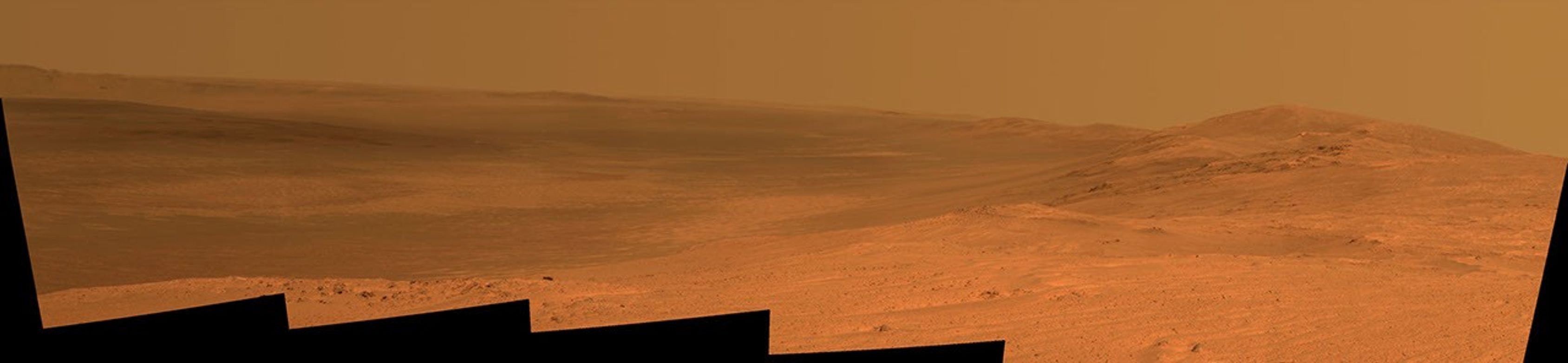 This vista of the Endeavour Crater rim was acquired by NASA's Mars Exploration Rover Opportunity's panoramic camera on April 18, 2014, from the southern end of "Murray Ridge" on the western rim of the crater. In mid-May, the rover approached the dark outcrops on the flank of the hill at right.