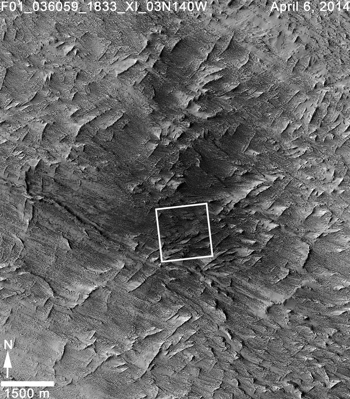 This April 6, 2014, image from the Context Camera on NASA's Mars Reconnaissance Orbiter was taken as a follow-up to discovery of a possible 2012 impact scar in images from the orbiter's Mars Color Imager. It reveals two craters within the darkened area (at center of the inscribed rectangle).