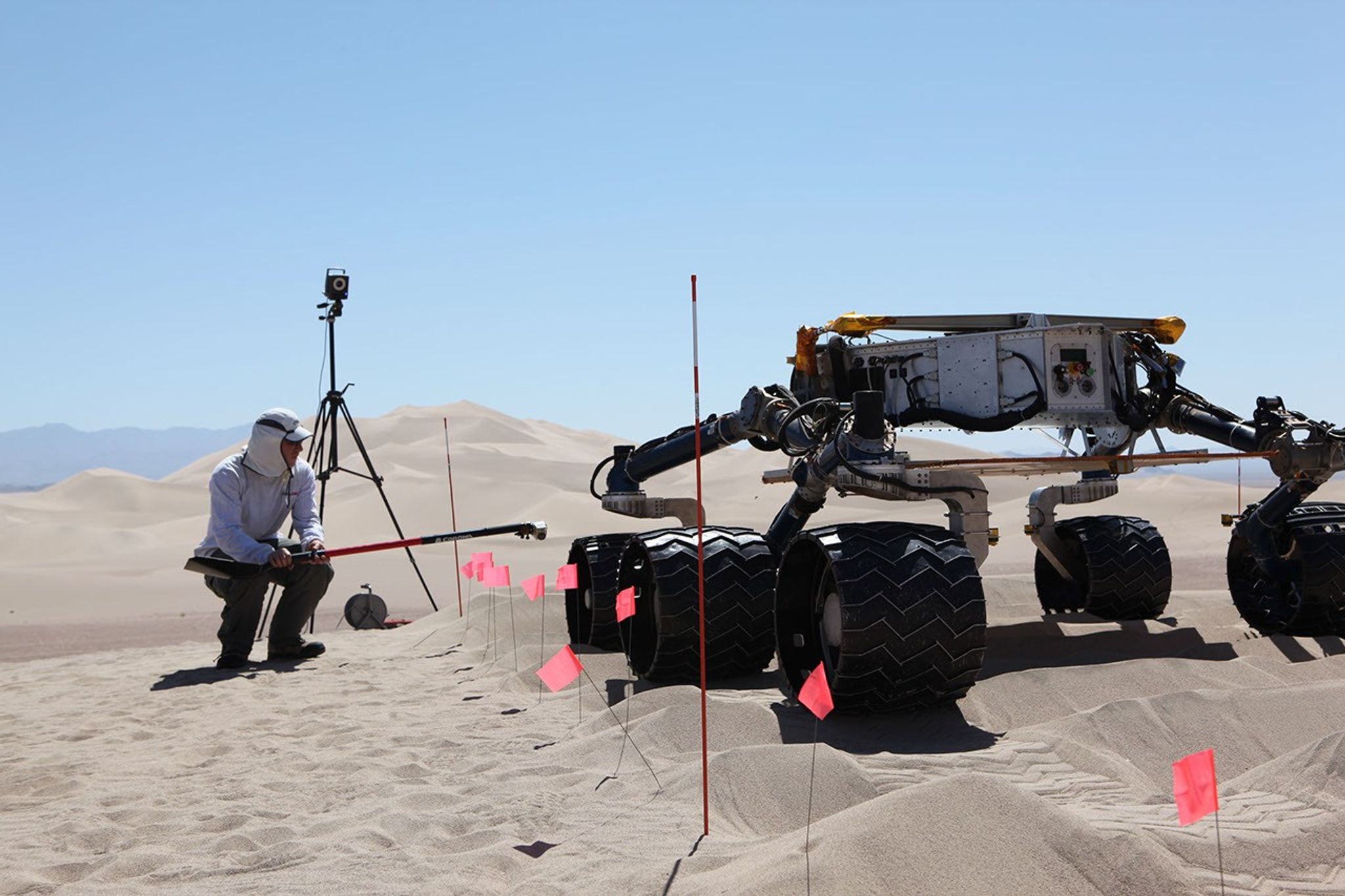 sand dune, mars rover, wheel, Dumont, Scarecrow, test - This image shows the scarecrow test rover going over a dunes obstacle course, while an engineer hunches down to see the wheels as it drives.