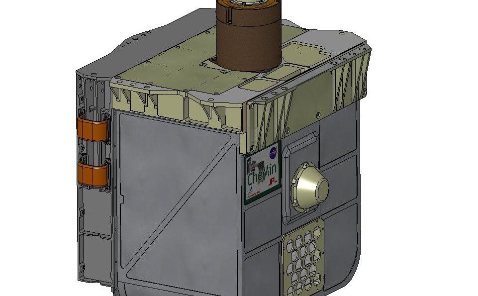 This sketch shows a transparent, rectangular chamber with a spoked wheel inside it. Around the outer edge of the wheel are slots for holding chemical samples.