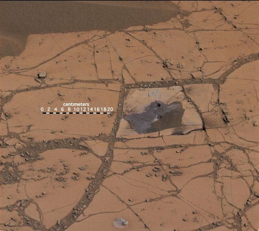 This image shows the first holes drilled by NASA's Mars rover Curiosity at Mount Sharp. The loose material near the drill holes is drill tailings and an accumulation of dust that slid down the rock during drilling.