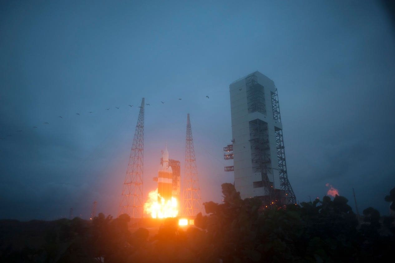 A Delta IV Heavy rocket roars to life at Space Launch Complex 37 at Cape Canaveral Air Force Station in Florida. The launch vehicle is carrying NASA's Orion spacecraft on an unpiloted flight test to Earth orbit. Liftoff was at 7:05 a.m. EST.