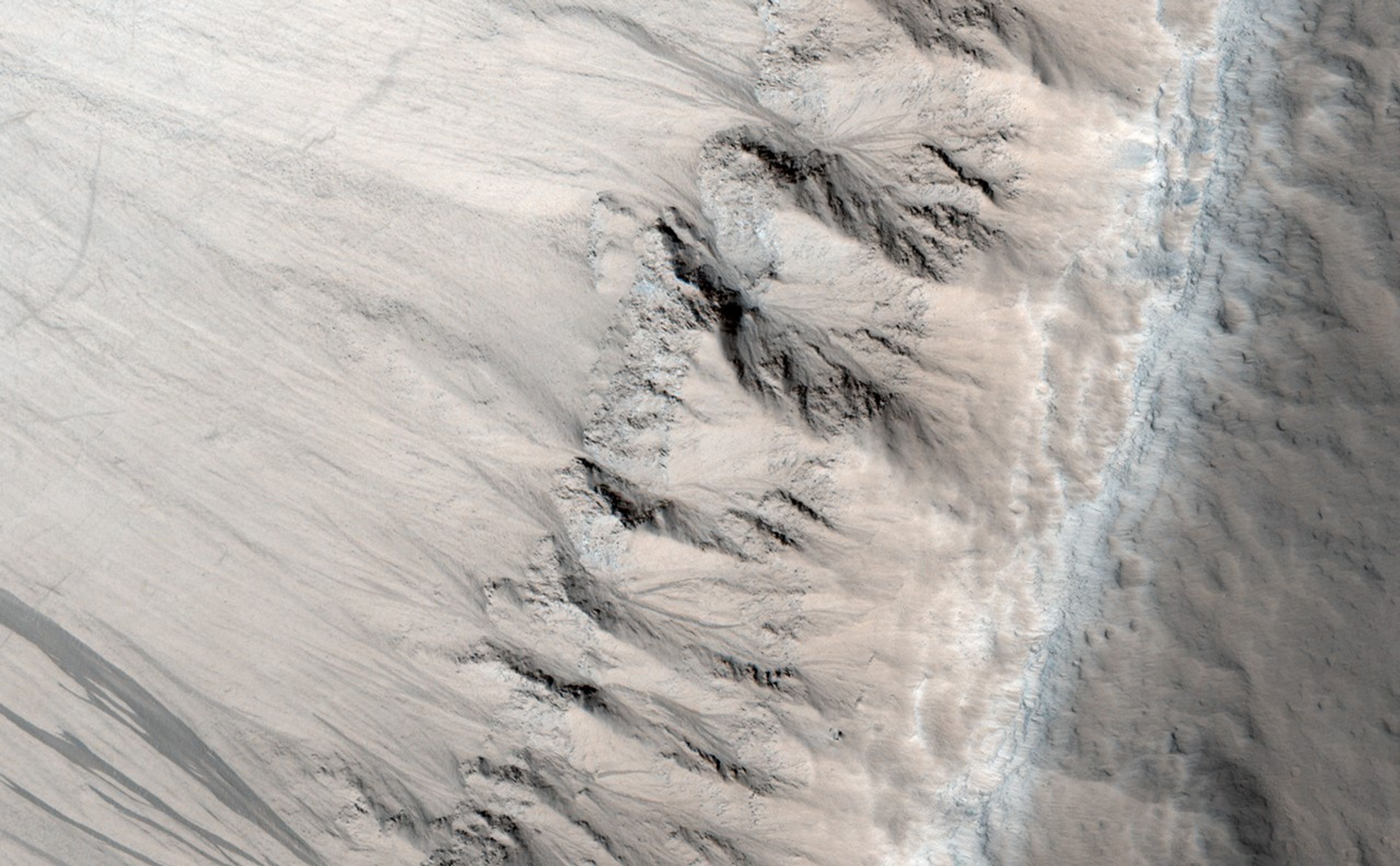 This image shows an exposure of layered rock that exhibits a type of fracturing -- called columnar jointing -- that results when cooling lava contracts.