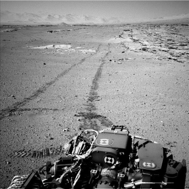 NASA's Curiosity Mars rover used its Navigation Camera (Navcam) for this look back after finishing a long drive on Feb. 19, 2014. The rows of rocks just to the right of the fresh wheel tracks in this view are an outcrop called "Junda."  This view is looking toward the east-northeast.