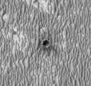 This image shows NASA's Mars Exploration Rover Opportunity perched on the edge of "Concepción" crater in Meridiani Planum, Mars.