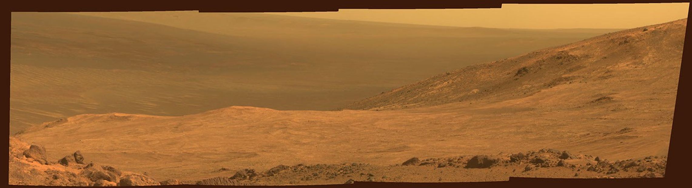 This view from NASA's Opportunity Mars rover shows part of "Marathon Valley," a destination on the western rim of Endeavour Crater, as seen from an overlook north of the valley. It was taken by the rover's Pancam on March 13, 2015. This version is in approximate true color.