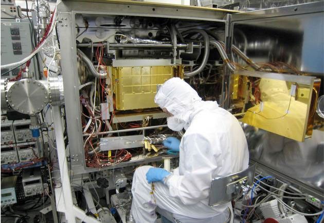 A Sample Analysis at Mars (SAM) team member at NASA's Goddard Space Flight Center in Maryland prepares the SAM testbed for an experiment.  This test copy of SAM is inside a chamber that can model the pressure and temperature environment that SAM sees inside NASA's Curiosity rover on Mars.