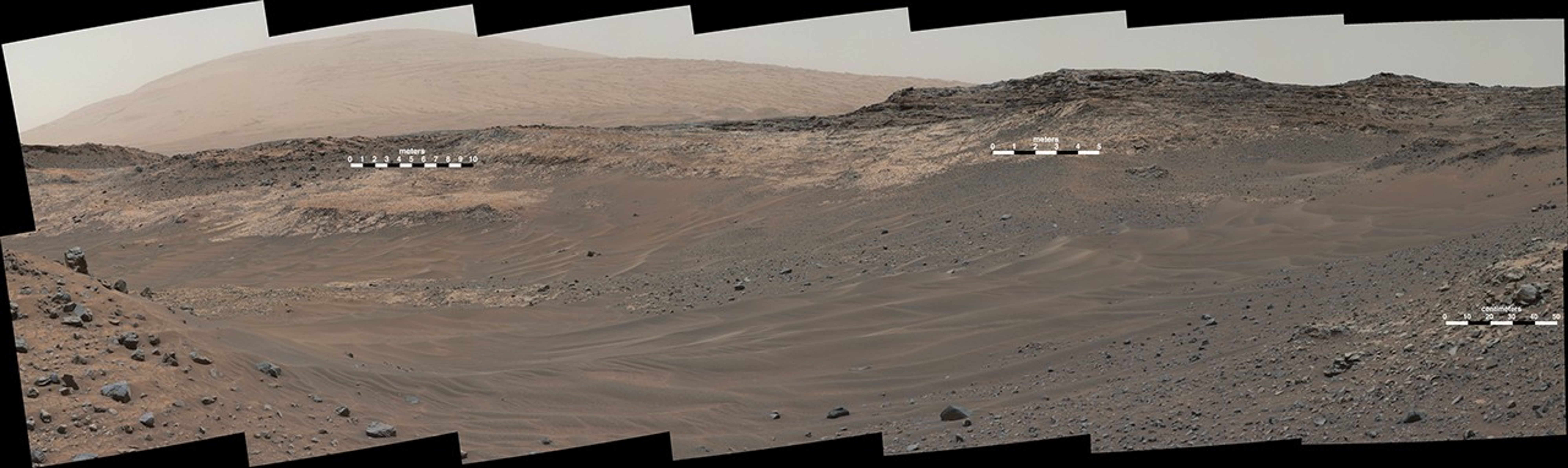 This May 10, 2015, view from Curiosity's Mastcam shows terrain judged difficult for traversing between the rover and an outcrop in the middle distance where a pale rock unit meets a darker rock unit above it. The rover team decided not to approach this outcrop and identified an alternative.