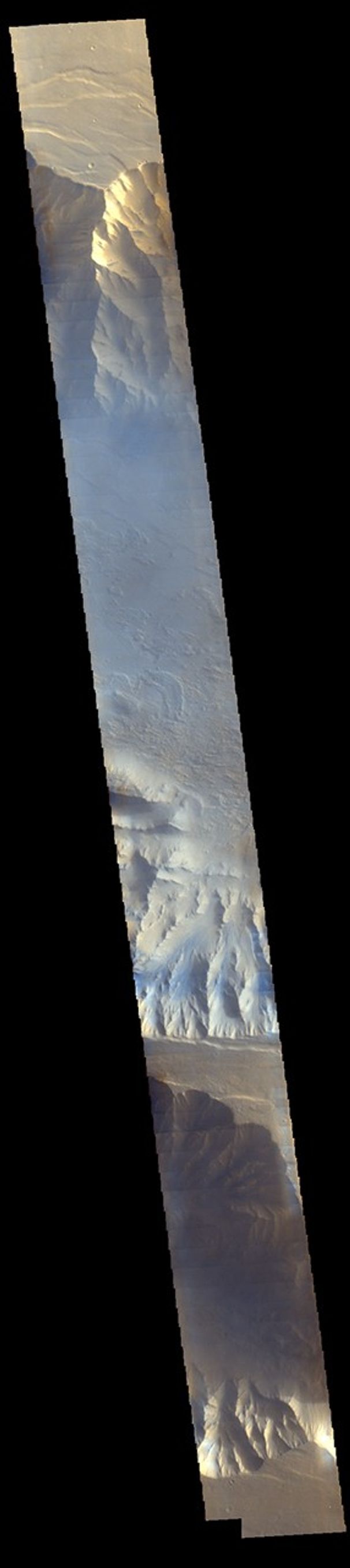 Morning clouds fill Coprates Chasma on Mars in this Nov. 25, 2015, image from the THEMIS camera on NASA's Mars Odyssey. No orbiter systematically observed Mars in morning sunlight before 2015. The clouds appear blue because ice particles in them scatter blue light more strongly than other colors.