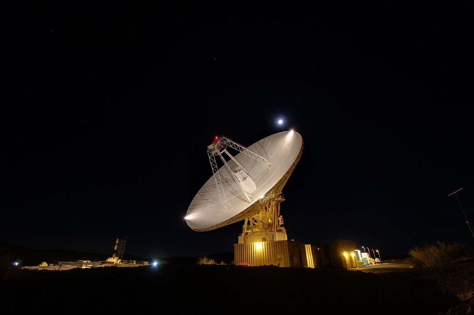 Goldstone's 230-foot (70-m) antenna tracks under a full moon. This photograph was taken on Jan. 11, 2012.