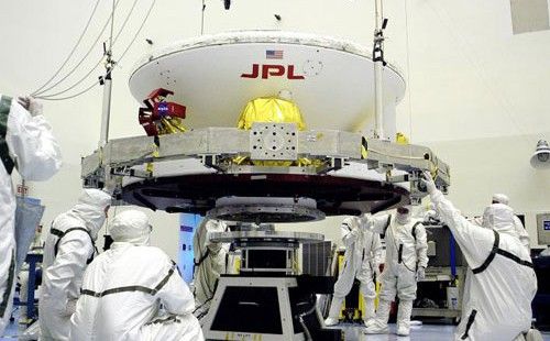 Engineers work on Opportunity (in its cruise configuration) in a cleanroom at Kennedy Space Center. A very important part of planetary protection is keeping contaminants from humans from riding aboard spacecraft. The pictured engineers are donning "bunny suits" that only allow their eyes to be exposed.
