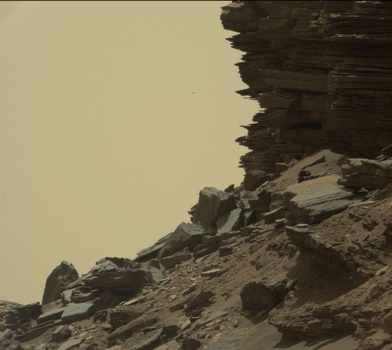 This view from Curiosity shows a dramatic hillside outcrop with sandstone layers that scientists refer to as "cross-bedding."