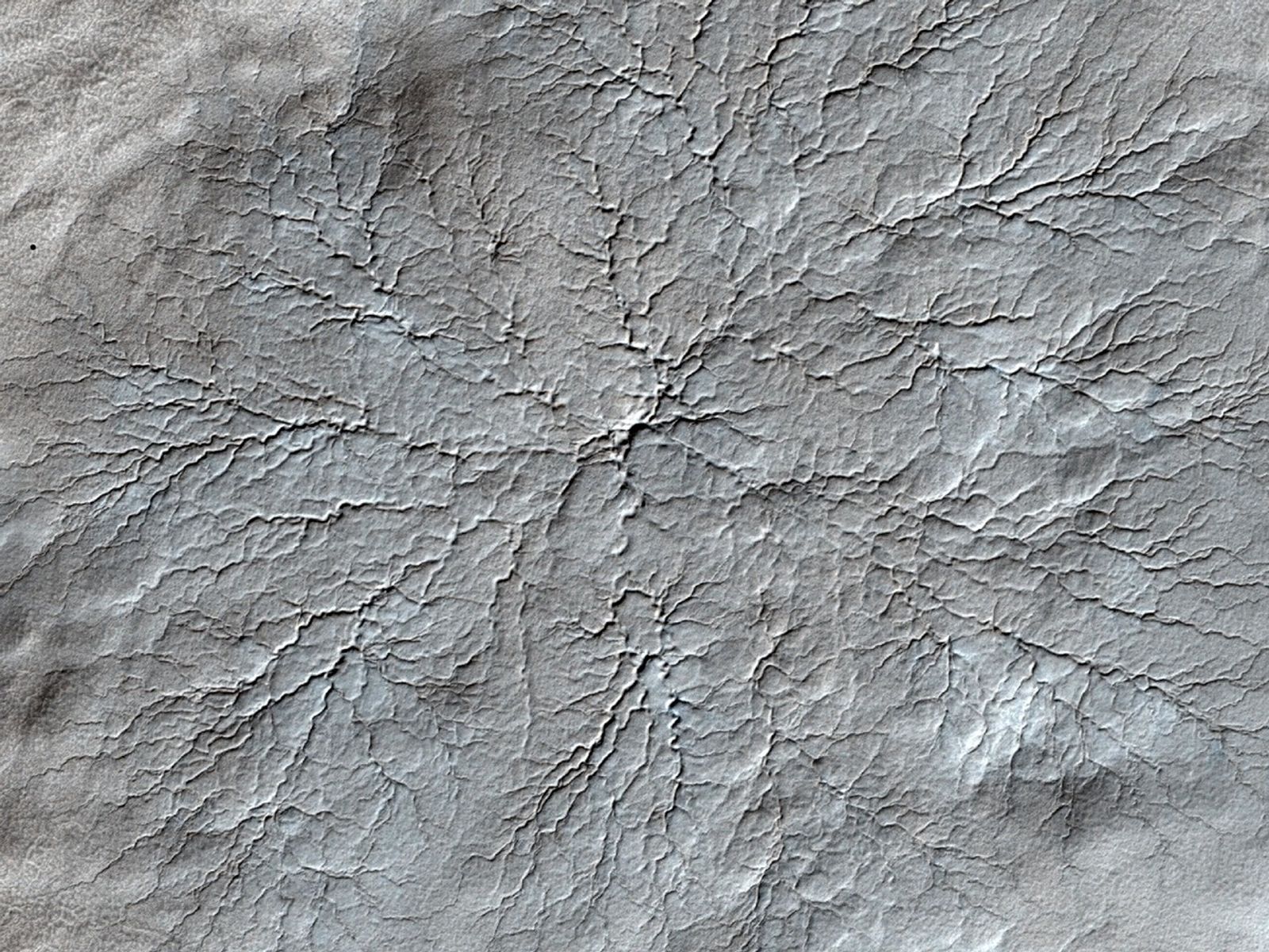 This HiRISE image shows erosional features formed by seasonal frost near the south pole of Mars.