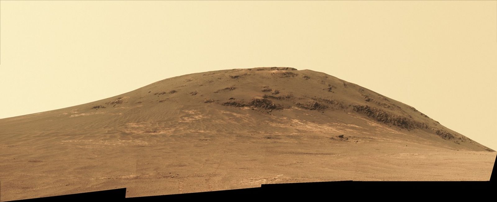 Wheel tracks from NASA's Mars rover Opportunity descending and departing the "Cape Tribulation" segment of Endeavour Crater's rim are visible in this April 21, 2017, view from the rover's Panoramic Camera (Pancam). The rover looked back northward during its trek south to "Perseverance Valley."
