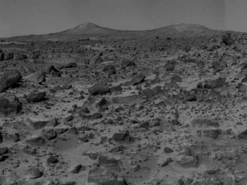The two hills in the distance, approximately one to two kilometers away, have been dubbed the 'Twin Peaks.' The image was taken by NASA's Imager for Mars Pathfinder (IMP) after its deployment on July 7, 1997.