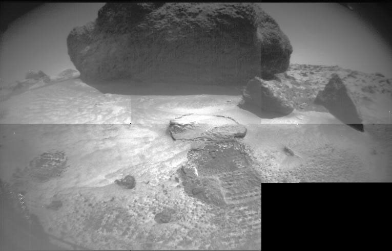 Taken from NASA's rover Sojourner's front stereo camera, this image features the large rock 'Yogi' and hole dug by the front wheel of the rover into the Martian soil.